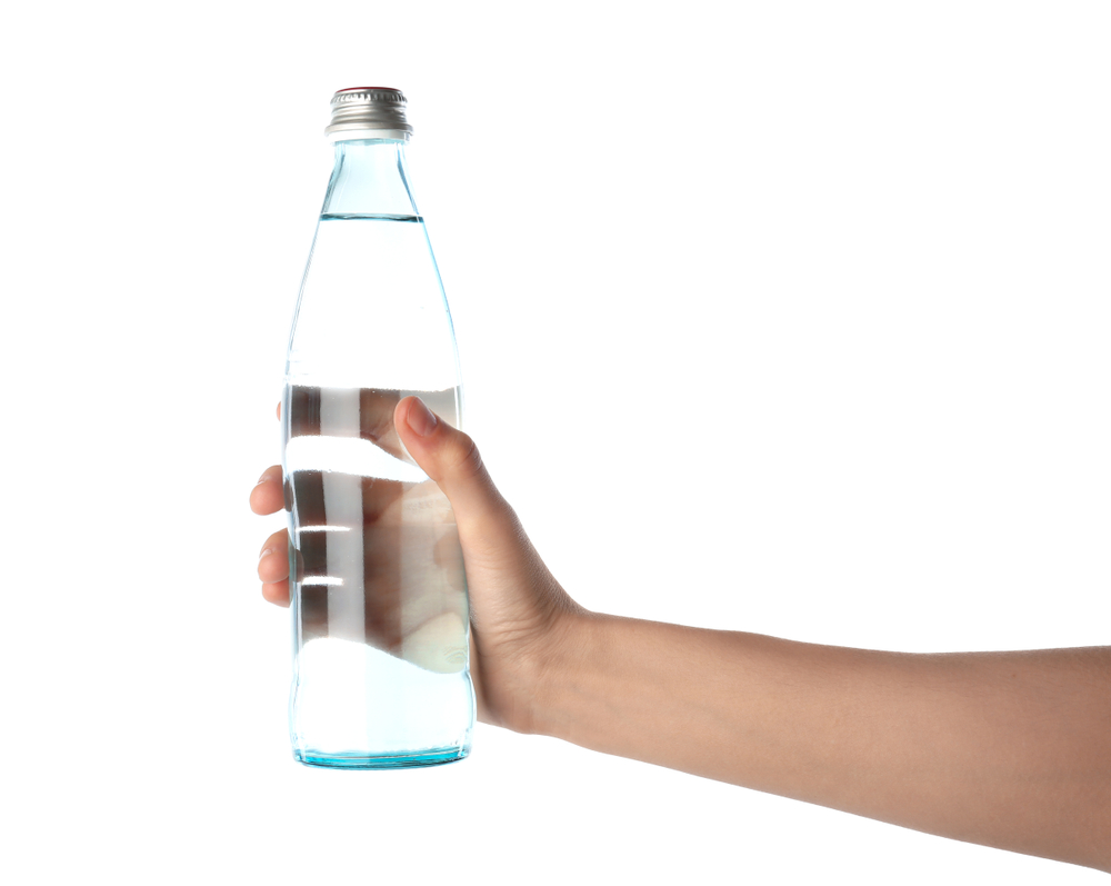 Hand mit Glasflasche Wasser