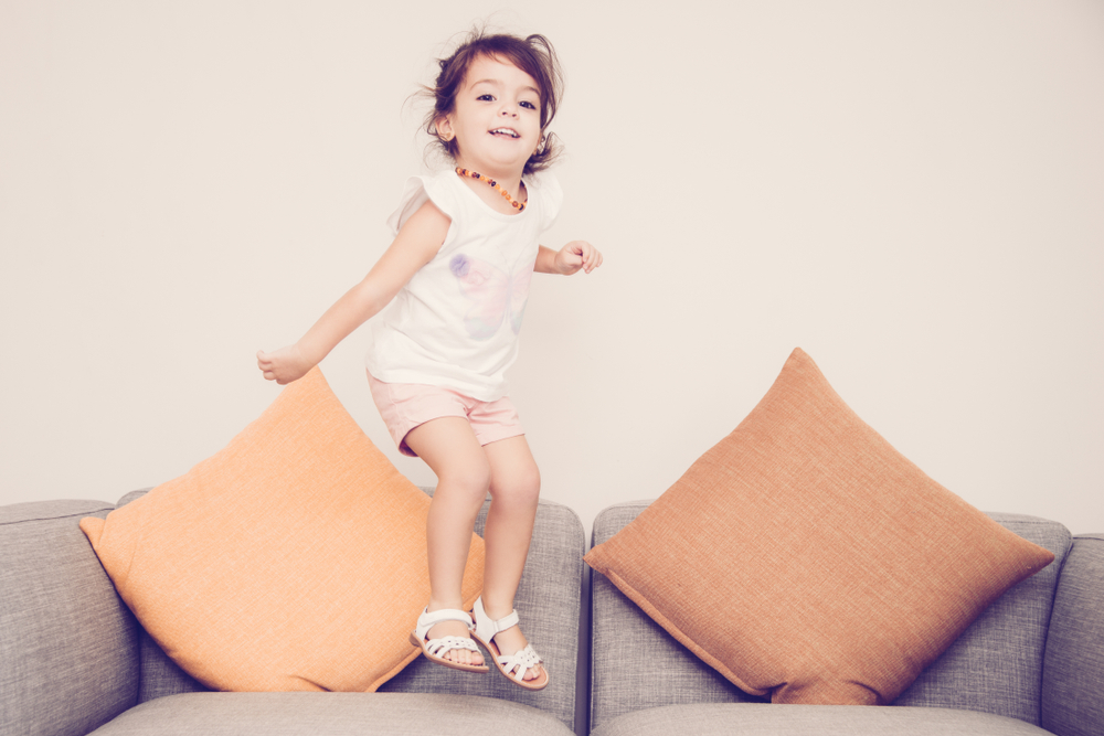 Kind hüpft auf Couch