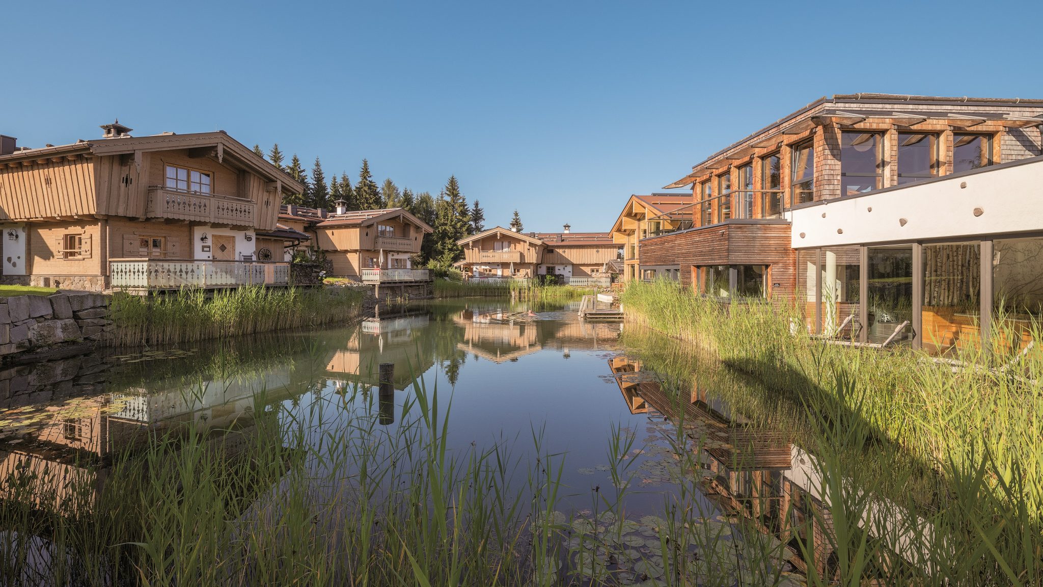 ansicht_des_resorts_im_sommer_mit_teichanlage_inns_holz_natur-_vitalhotel_und_chaletdorf_boehmerwald