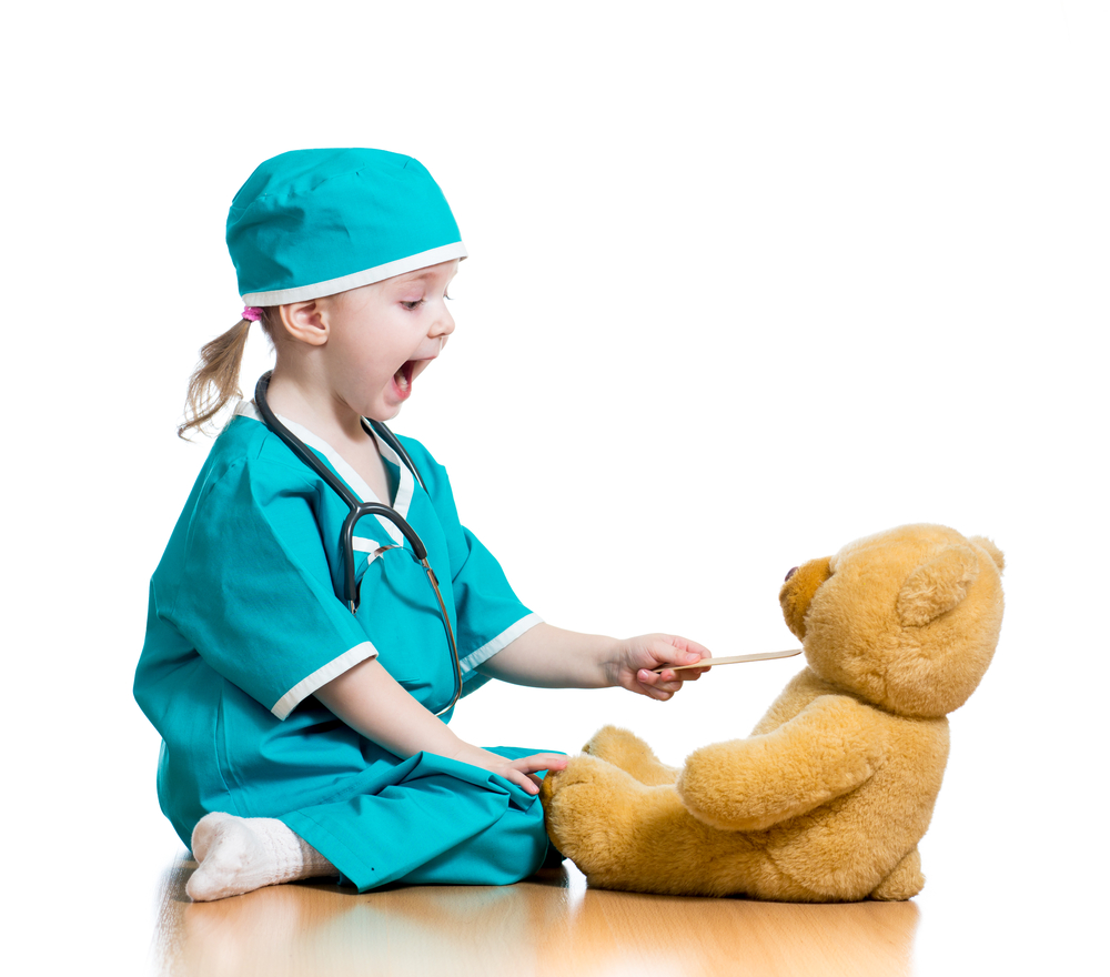 Kind spielt Doktor mit Teddy