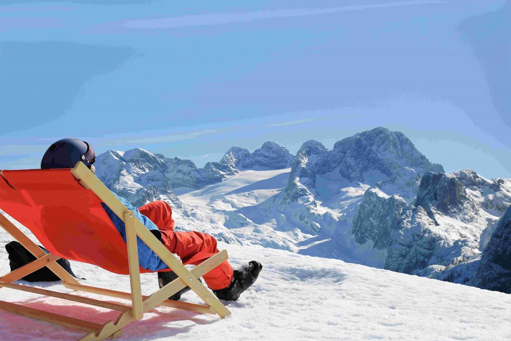 Skier enjoying the nice weather in the deck chair