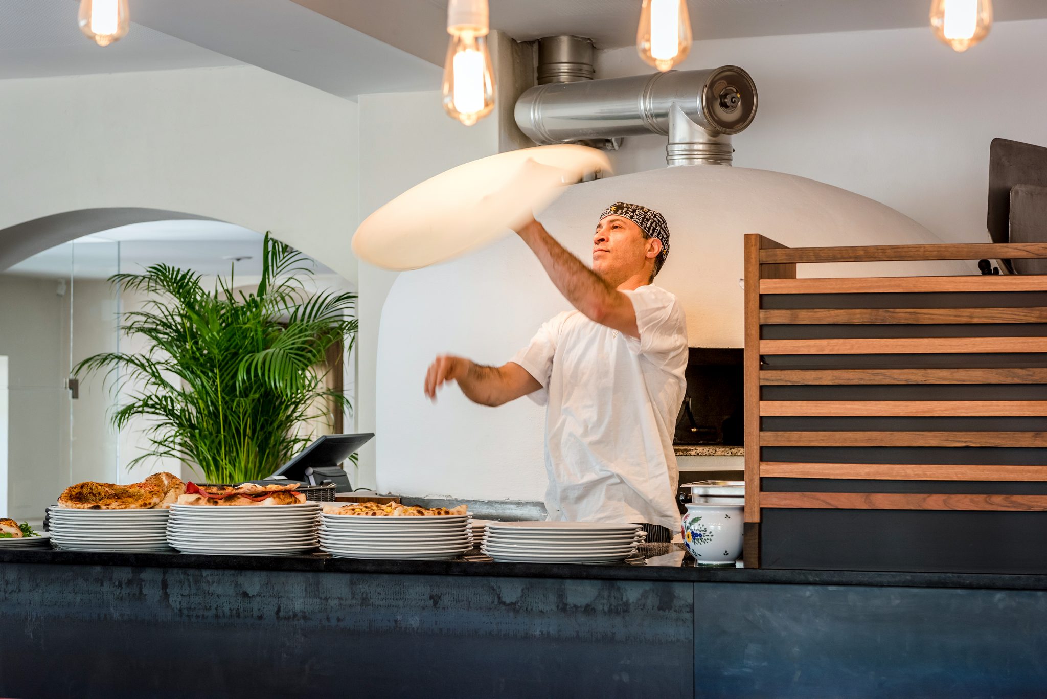 pizzabaecker_beim_zubereiten_von_pizzaboden_c_guenter_standl_hotel_botango