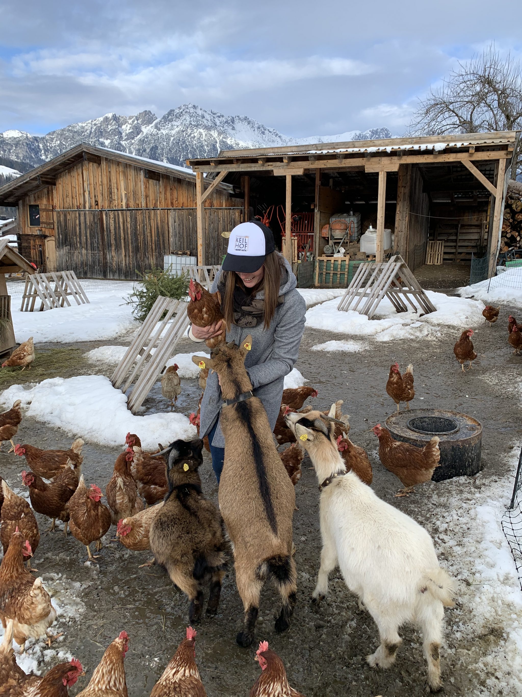 Julia Hölzl im mobilen Gehege mit Ziegen und Hennen
