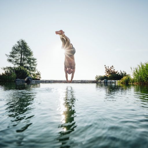 Mann springt in den Almsee im Wellnesshotel Feuerberg in Kärnten