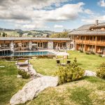aussenanlage_mit_outdoorpool_im_sommer_tirler-dolomites_living_hotel