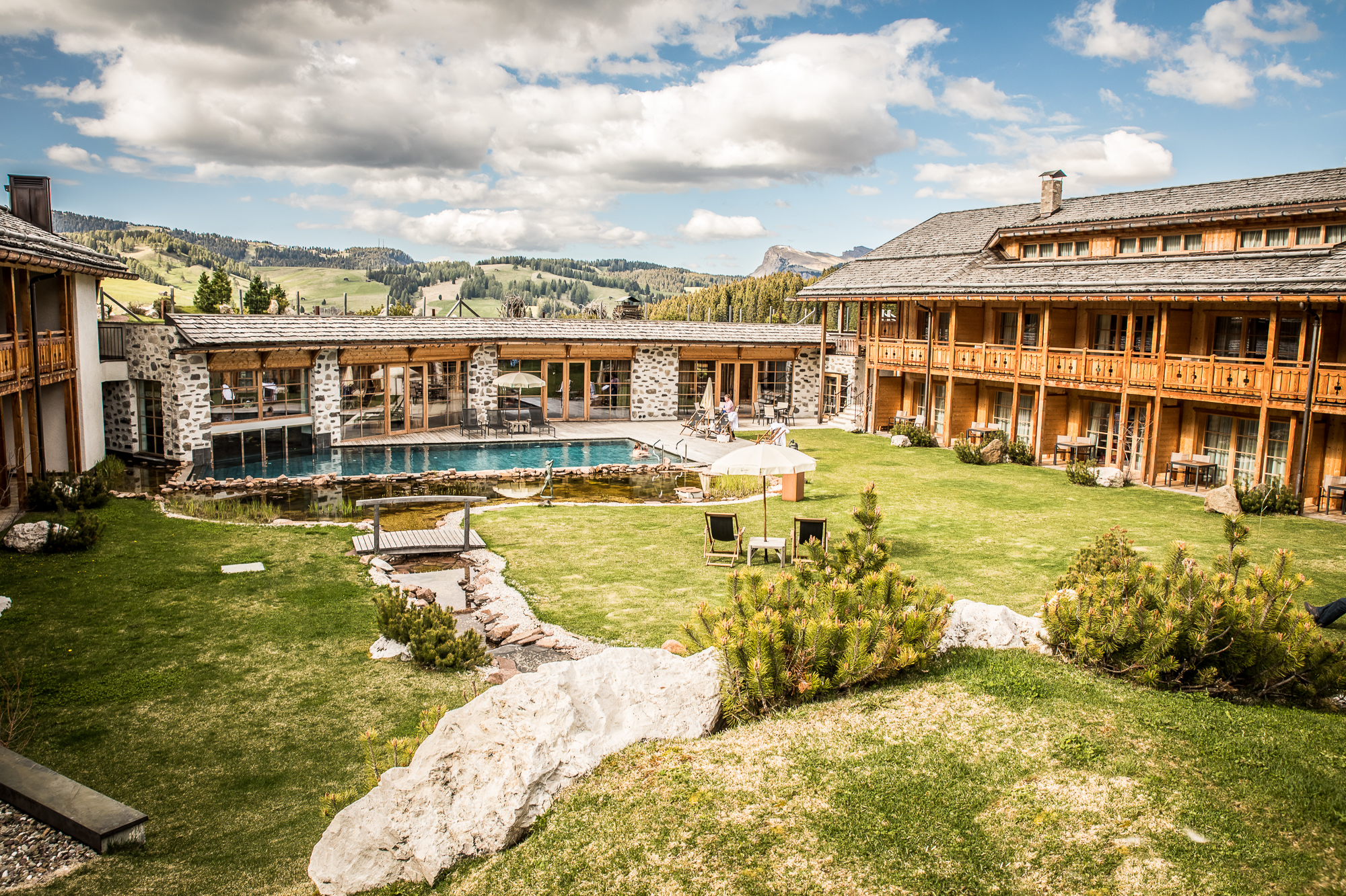 aussenanlage_mit_outdoorpool_im_sommer_tirler-dolomites_living_hotel