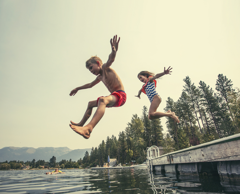 Kids,Jumping,Off,The,Dock,Into,A,Beautiful,Mountain,Lake.