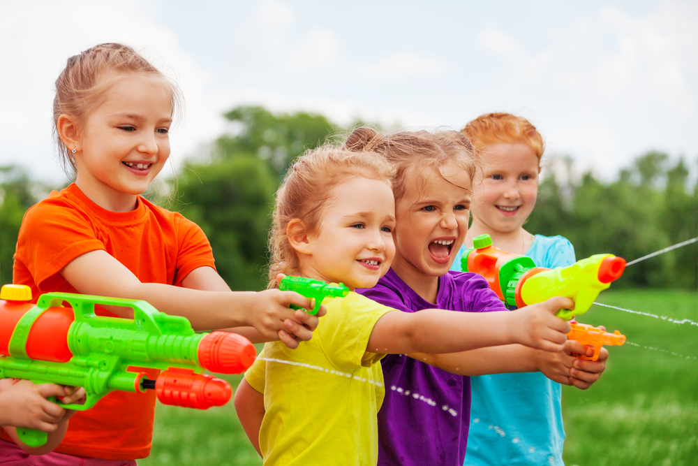 Children,Playing,Outdoors,With,Water,Guns,On,A,Beautiful,Sunny