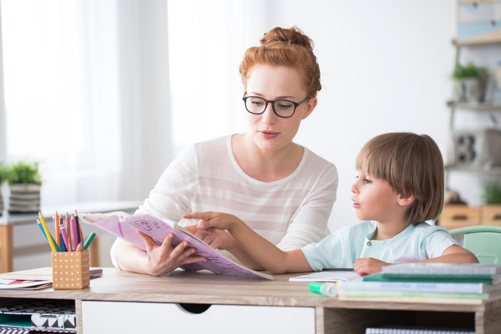 Young,Boy,Doing,Homework,During,Extra-curricular,Classes,With,A,Tutor