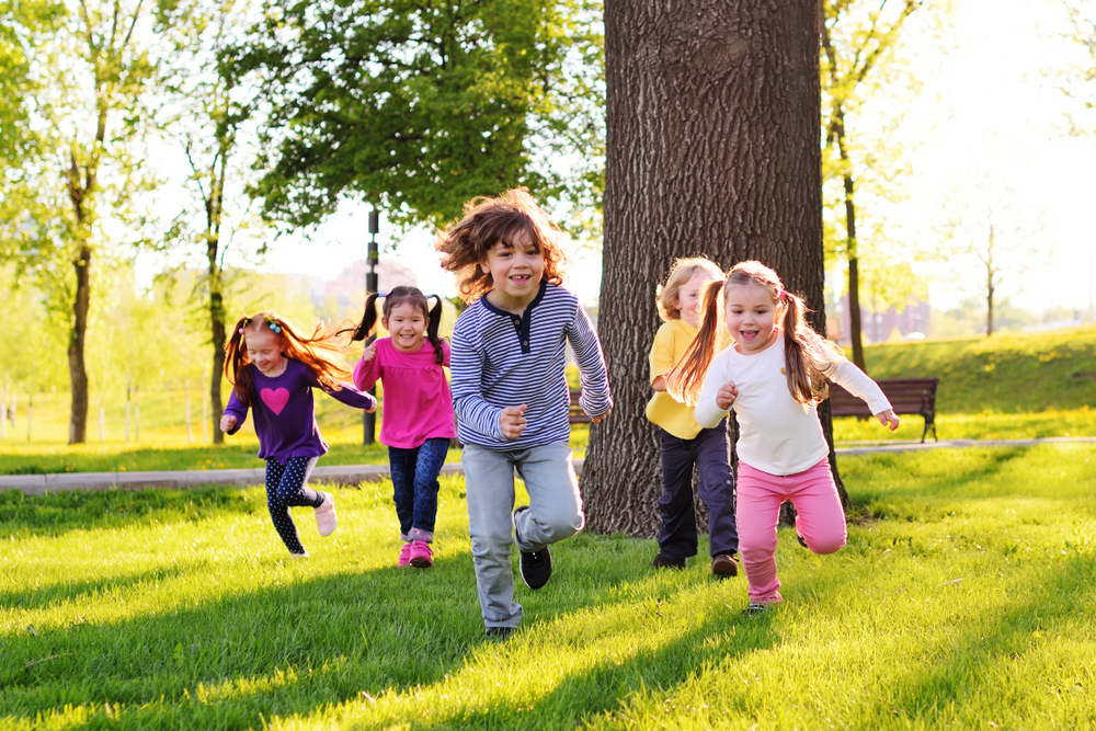 A,Group,Of,Small,Happy,Children,Run,Through,The,Park