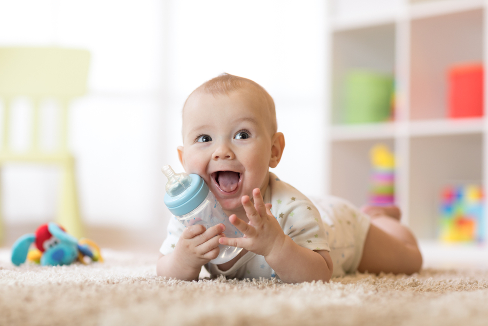 Cute,Baby,Boy,Drinking,From,Bottle.,Kid,Lying,On,Carpet