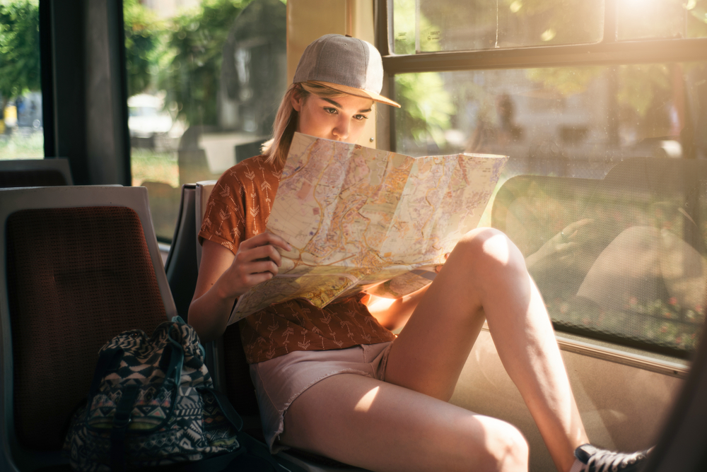 Young,Teenage,Girl,Traveling,And,Using,Map,For,Orientation,In