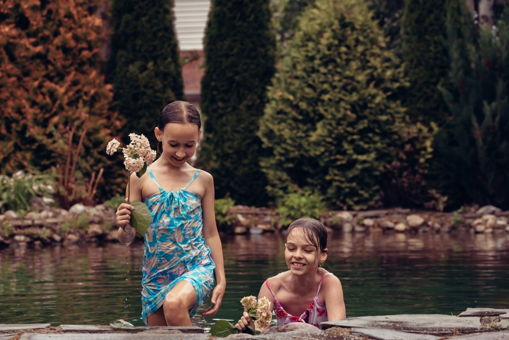 Two,Little,Girls,In,Summer,Dresses,Swim,In,A,Pond