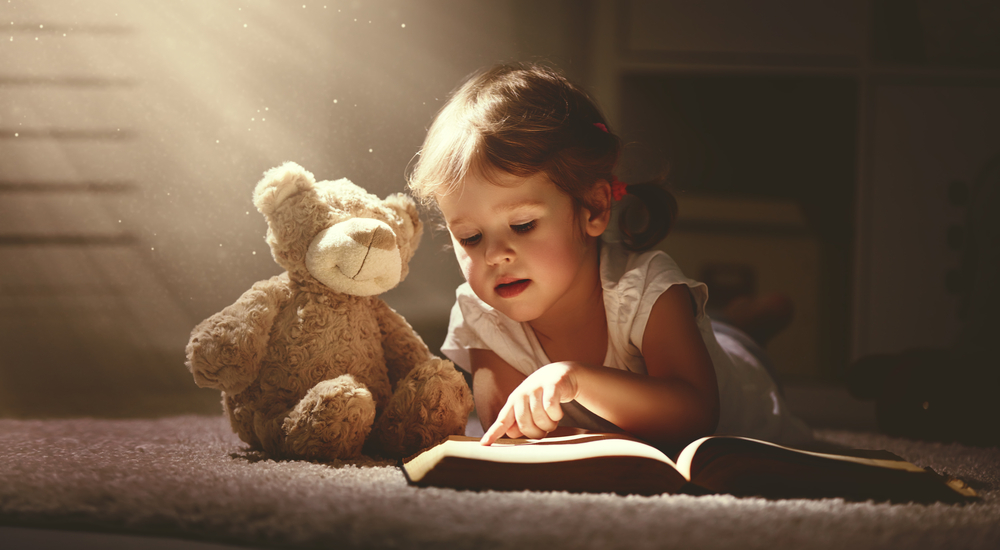 Child,Little,Girl,Reading,A,Magic,Book,In,The,Dark