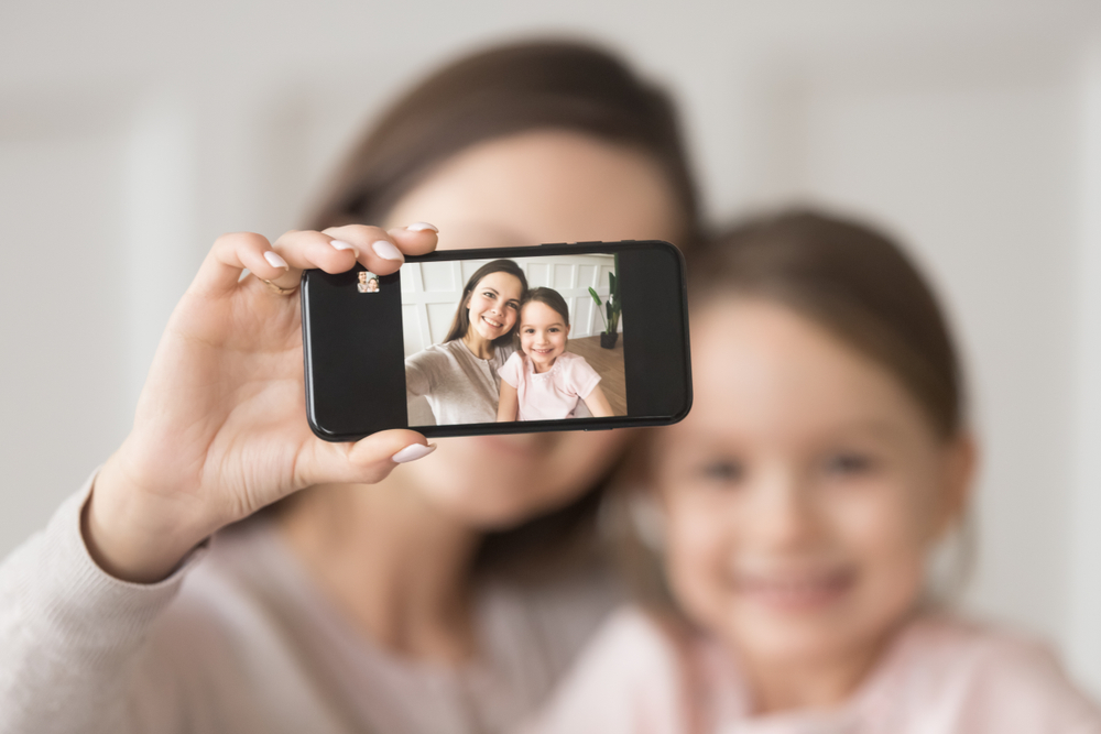 Happy,Young,Mother,Holding,Phone,Taking,Selfie,On,Cellphone,Embracing