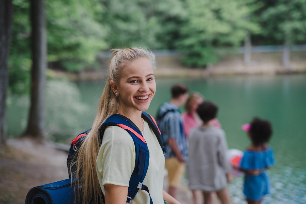 Young,Woman,With,Friends,On,A,Hiking,Or,Camping,Trip