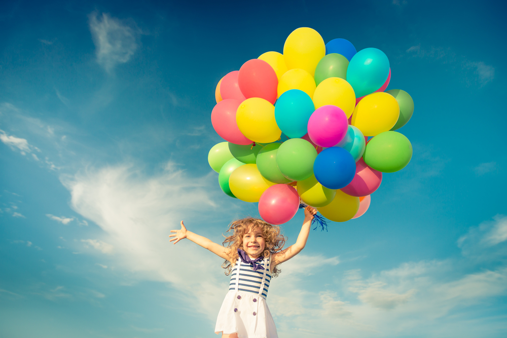 Happy,Child,Jumping,With,Colorful,Toy,Balloons,Outdoors.,Smiling,Kid