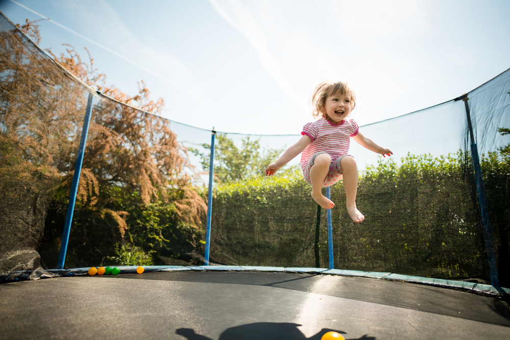 Little,Child,Enjoys,Jumping,On,Trampoline,-,Outside,In,Backyard