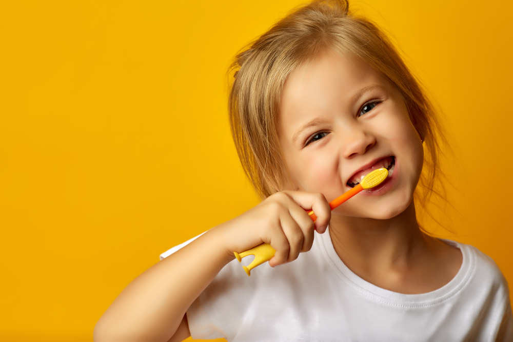 Charming,Little,Girl,In,White,T-shirt,Cleaning,Teeth,With,Colorful