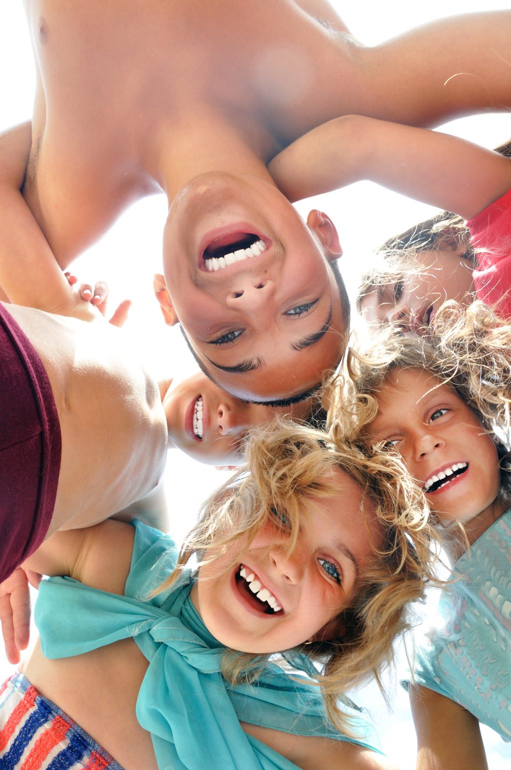 group of happy smiling friends playing together outdoor on a sunny summer day