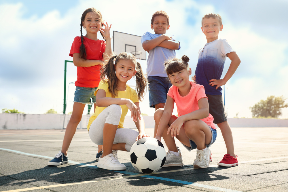 Cute,Children,With,Soccer,Ball,At,Sports,Court,On,Sunny