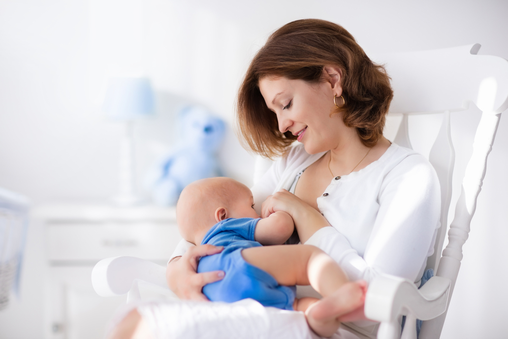 Young,Mother,Holding,Her,Newborn,Child.,Mom,Nursing,Baby.,Woman