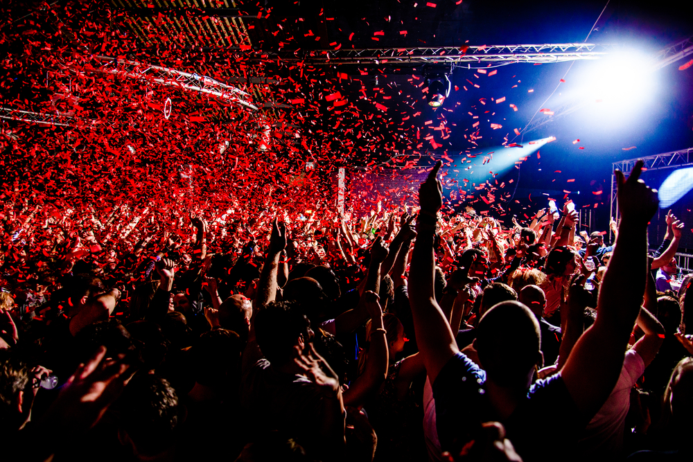 Nightclub,Party,Clubbers,With,Hands,In,Air,And,Red,Confetti