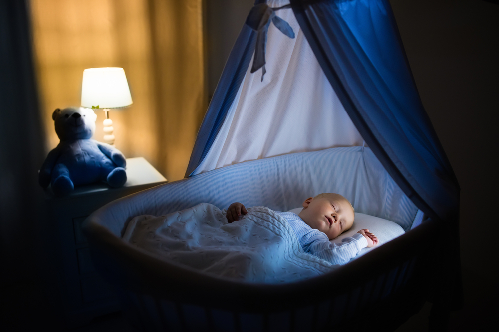Adorable,Baby,Sleeping,In,Blue,Bassinet,With,Canopy,At,Night.