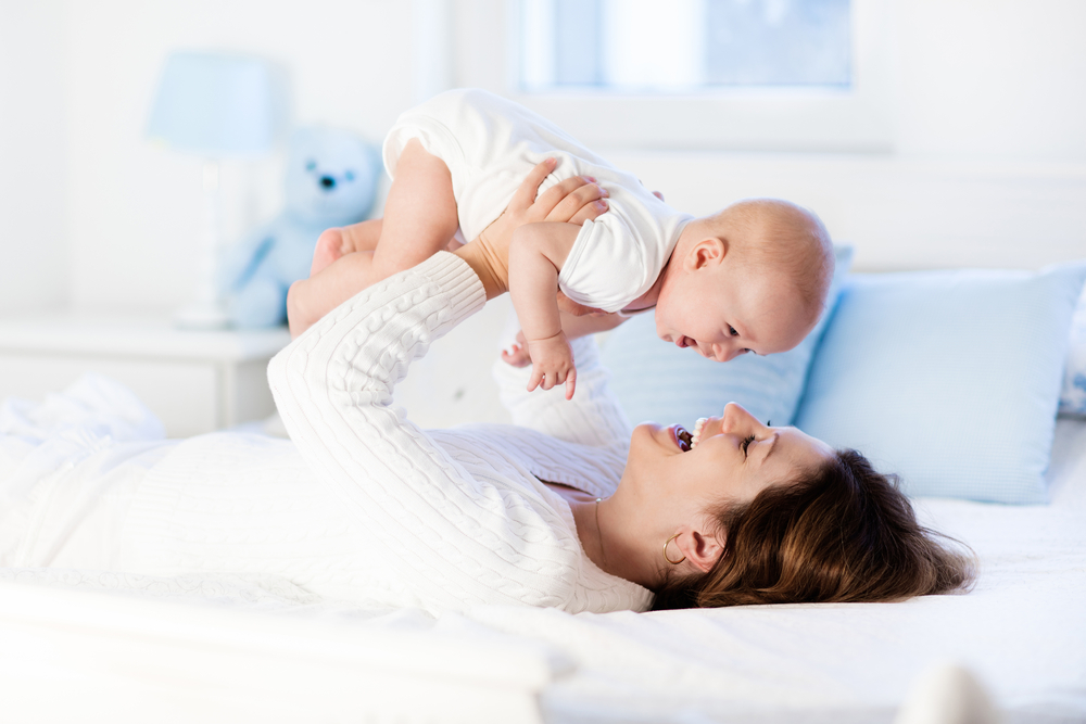 Mother,And,Child,On,A,White,Bed.,Mom,And,Baby