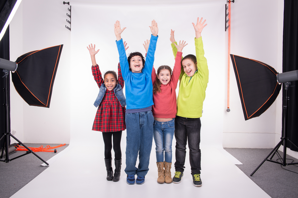 Group,Of,Children,Posing,With,Raised,Hands,In,A,Photo