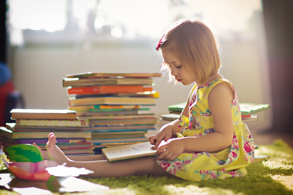 A,Little,Cute,Girl,In,A,Yellow,Dress,Reading,A