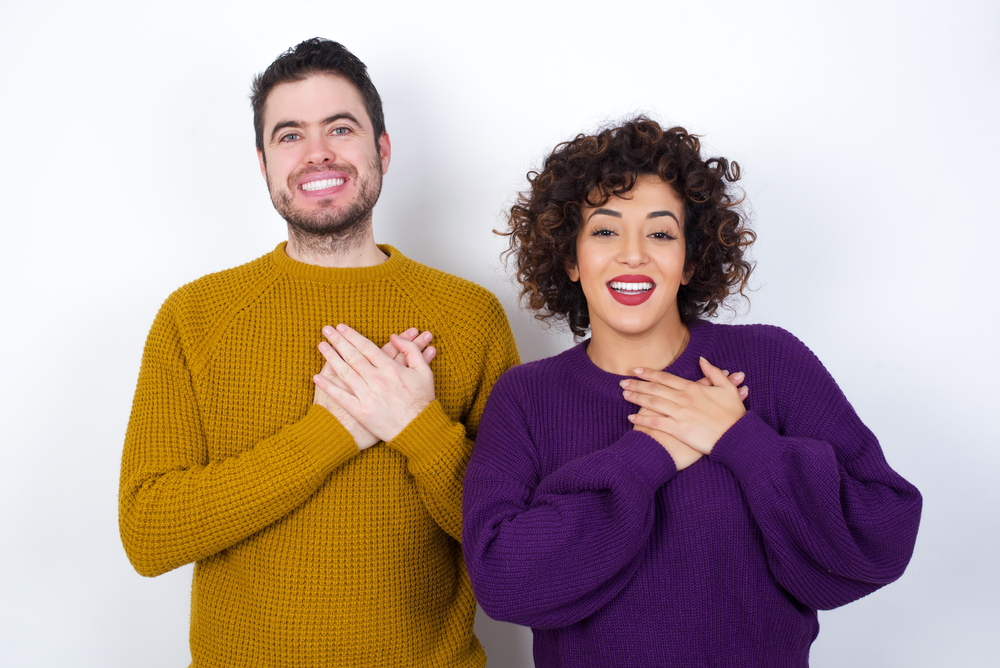 Honest,Young,Couple,Wearing,Knitted,Sweater,Standing,Against,White,Studio