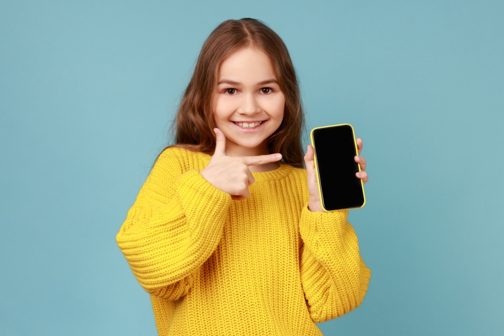 Portrait,Of,Little,Girl,Pointing,Finger,At,Blank,Screen,Of