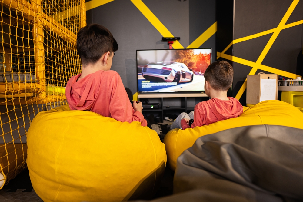 Two,Brothers,Playing,Race,Video,Game,Console,,Sitting,On,Yellow