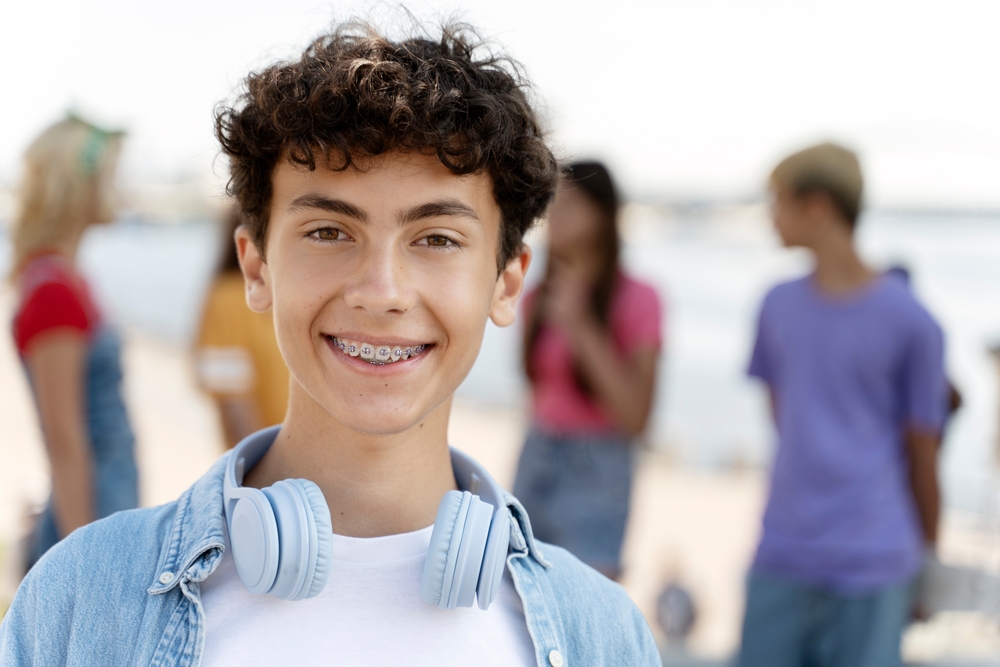 Portrait,Of,Smiling,Teenager,With,Braces,Wearing,Headphones,Looking,At